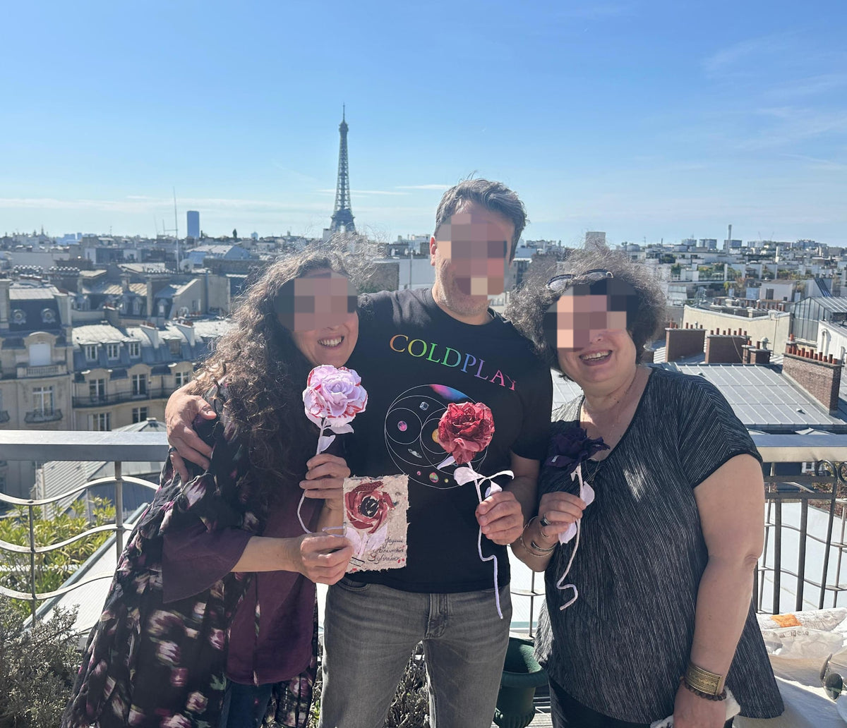 Famille partageant un moment de souvenir précieux avec leurs roses éternelles sur-mesure sur un balcon parisien.